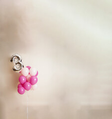 Pink balloon background with the number 3 silver balloon on a big beige background and space for...
