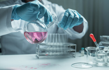 Scientist holding flask with lab glassware and chemistry laboratory test tubes Research and...