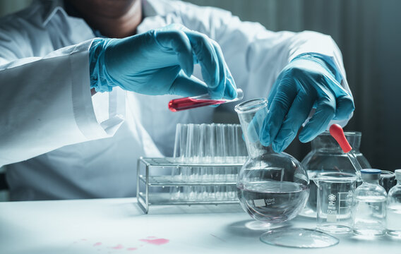 Scientist holding flask with lab glassware and chemistry laboratory test tubes Research and development in science laboratory, science technology concept
