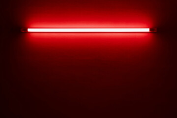 red neon light bulb on white wall..