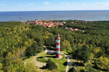 Nida Lighthouse is located in Nida, on the Curonian Spit in between the Curonian Lagoon and the Baltic Sea - obrazy, fototapety, plakaty
