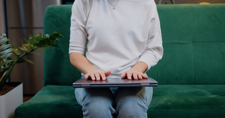 Women's hands finishing her workday at home and closes a laptop close up. Remote learning at home via a laptop webcam