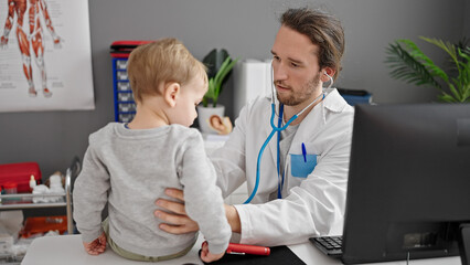 Obraz premium Father and son doctor examining child at clinic