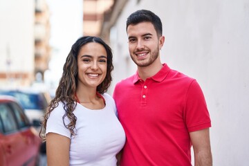 Fototapeta premium Young hispanic couple smiling confident hugging each other at street