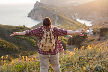 An overweight woman walks in the mountains, actively spends her weekend, active life, active lifestyle, excess weight.