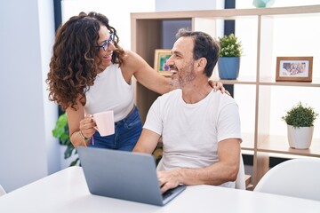Man and woman couple smiling confident using laptop at home