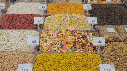 Market stall with various dried fruits and nuts. Local market. Bright colored nuts and dried...