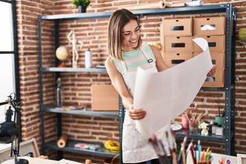 Young beautiful hispanic woman artist smiling confident looking draw at art studio