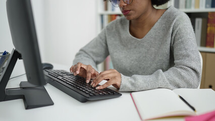 African american woman student using computer studying at library university