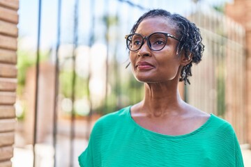 Middle age african american woman wearing glasses with serious expression at street