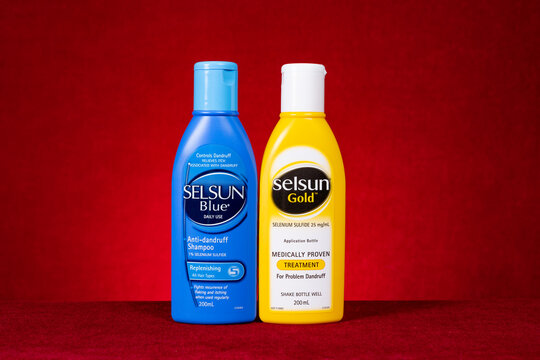 ZhongShan China-March 28,2023:bottles of Selsun Gold and Selsun Blue on red background horizontal composition.