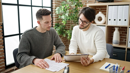 Two men business partners reading document at office