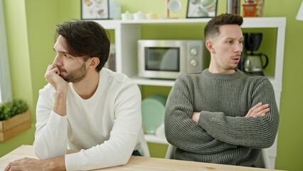 Two men couple with unhappy expression at dinning room