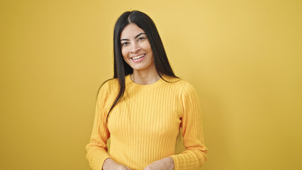 Obraz premium Young beautiful hispanic woman smiling confident standing over isolated yellow background