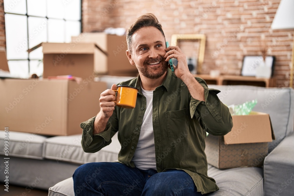 Sticker young caucasian man talking on smartphone drinking coffee at new home