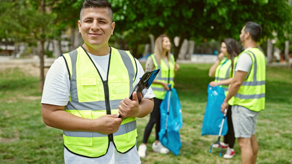 Group of people volunteers holding clipboard smiling confident at park