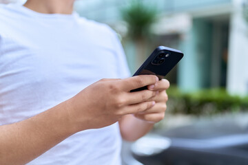 Non binary man using smartphone at street