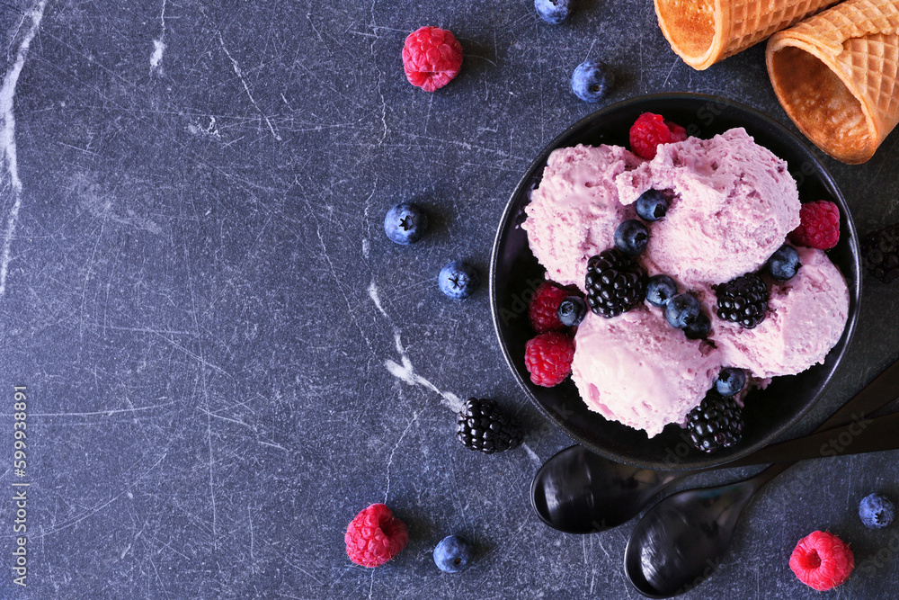 Poster Bowl of field berry ice cream. Overhead view table scene with copy space over a dark stone background.