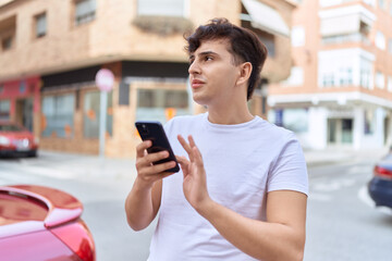 Fototapeta na wymiar Non binary man using smartphone with relaxed expression at street