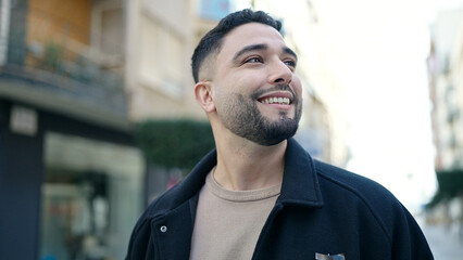 Young arab man smiling confident looking to the side at street