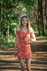 Fototapeta premium Portrait of a young beautiful blonde girl in a summer park.