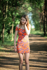 Fototapeta premium Portrait of a young beautiful blonde girl in a summer park.