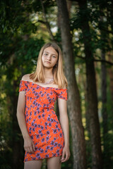Fototapeta premium Portrait of a young beautiful blonde girl in a summer park.
