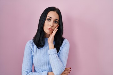 Hispanic woman standing over pink background thinking looking tired and bored with depression...