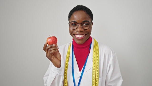 African american woman dietician smiling confident holding apple over isolated white background