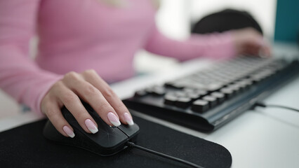 Young blonde woman student using computer studying at library university