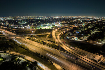 Fototapeta na wymiar Above view of wide highway crossroads in Miami, Florida at night with fast driving cars. USA transportation infrastructure concept