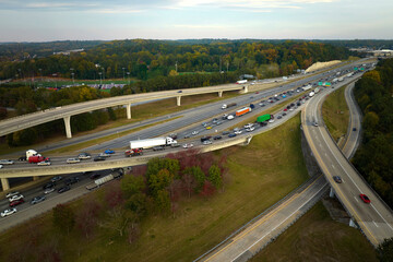 Aerial view of american freeway intersection with fast moving cars and trucks. USA transportation...