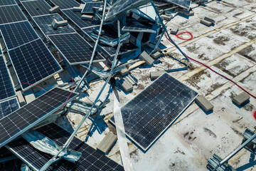 Aerial view of damaged by hurricane wind photovoltaic solar panels mounted on industrial building...