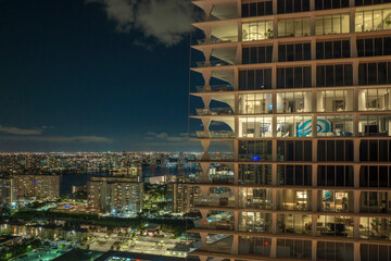 Aerial view of residential high-rise skyscraper at night in Sunny Isles Beach city in Florida, USA. Housing development in modern american urban area