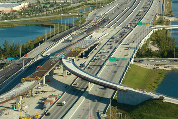 Fototapeta na wymiar Industrial roadworks in Miami, Florida. Wide american highway junction under construction. Development of interstate transportation system for rapid transit for long distance travelling