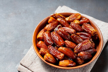 Delicious dried dates on a plate. Pitted dates on a dark background. Dried fruits for a healthy diet