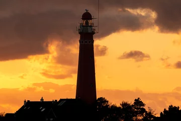 Tuinposter the red lighthouse in Schiermonnikoog  in front of the sunset © Daniel Doorakkers