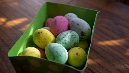 Small multicolored eggs. Small chocolate eggs in a box. Small eggs of different colors close-up