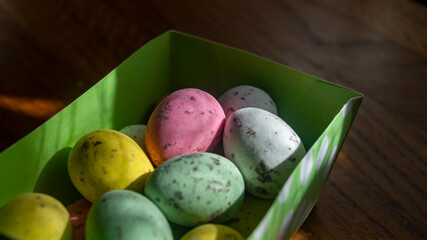 Small multicolored eggs. Small chocolate eggs in a box. Small eggs of different colors close-up