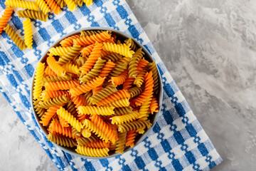 Raw fusilli pasta on concrete. Colorful italian raw pasta on a linen napkin. Italian cuisine