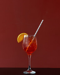 red cocktail with ice and orange