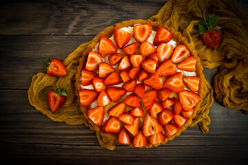 Pie with fresh strawberries on old background