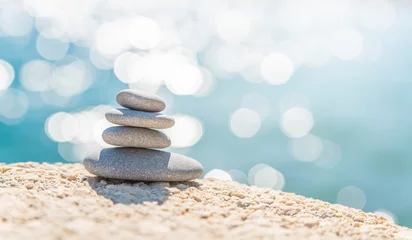 Fotobehang Zen Stenen Pyramid stones on the seashore on a sunny day on the blue sea background. Happy holidays. Pebble beach, calm sea, travel destination. Concept of happy vacation on the sea, meditation, spa, calmness.  © Jam