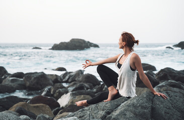 Fototapeta na wymiar Woman practicing yoga on the beach. Active Travel Healthy Yoga Lifestyle.