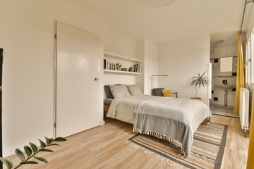 a bedroom with white walls and wood flooring the room has a bed in it is surrounded by yellow curtains
