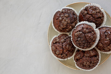 Homemade Dark Chocolate Muffins on a Plate, top view. Overhead, from above, flat lay. Space for text.