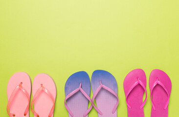 Many bright flip flops on color background, top view