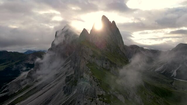 Breathtaking aerial view of the Seceda mountain peaks during a foggy sunrise in the Dolomites, Italy.