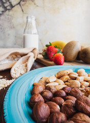 Breakfast, healthy homemade snack with nuts, strawberries, kiwi and cereal with milk.