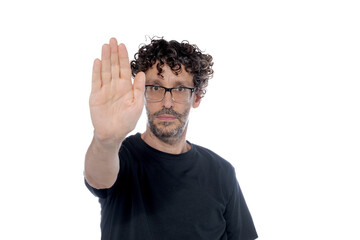 Middle-aged man raising the palm of his right hand, with stop gesture, on white background.